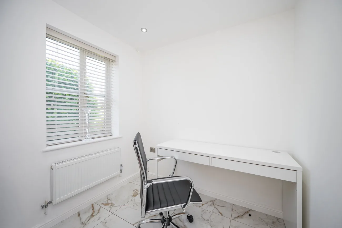 Ground-floor study with a fitted desk and a window to the garden