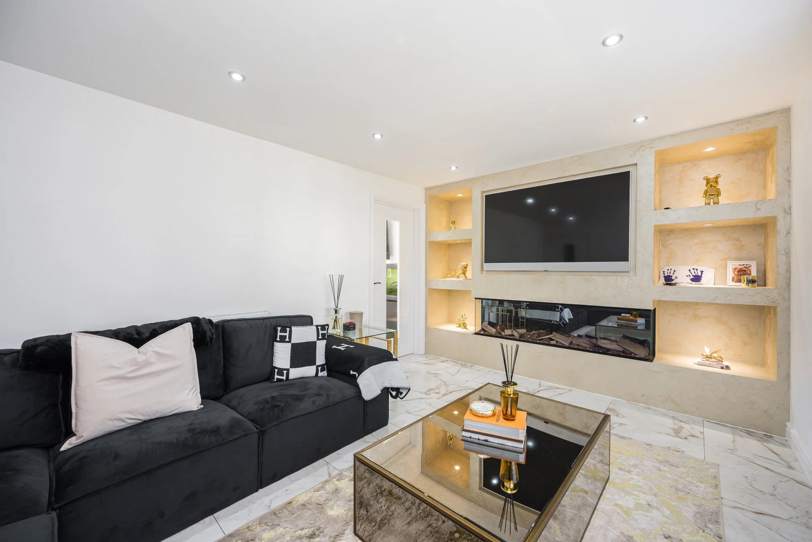 Sitting room with a feature media wall, inset living-flame fire and polished marble-effect floor