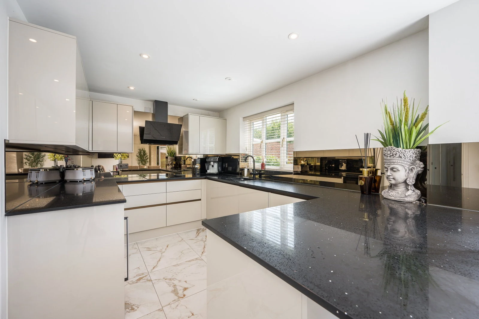 Kitchen with handleless gloss units, granite worktops and a large island