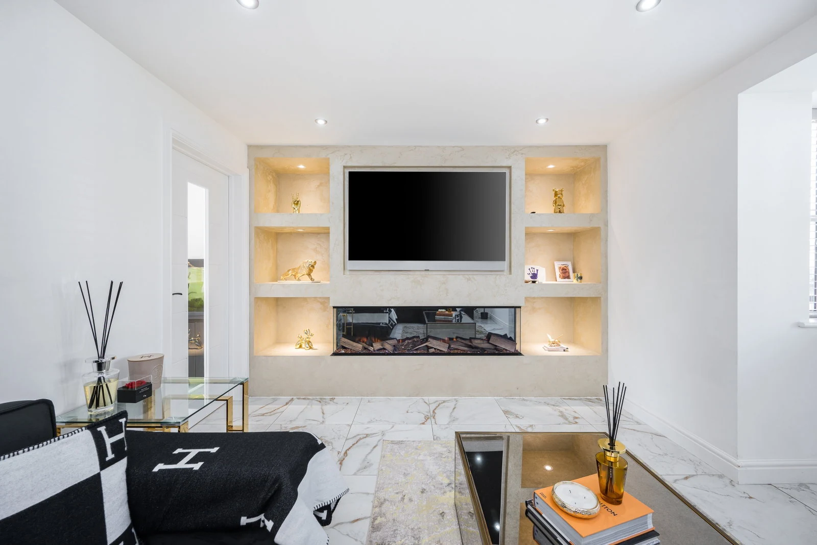 Living room media wall with an inset fire and backlit display niches